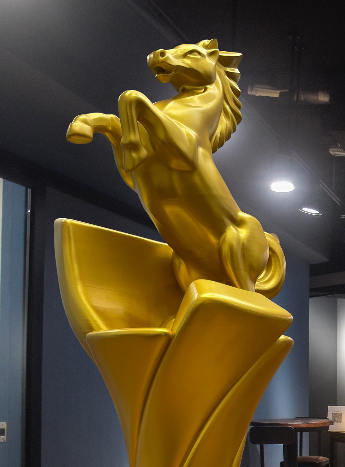 金馬雕塑上半部特寫,躍起的馬身與鬃毛細節,打磨後噴塗金色漆面
